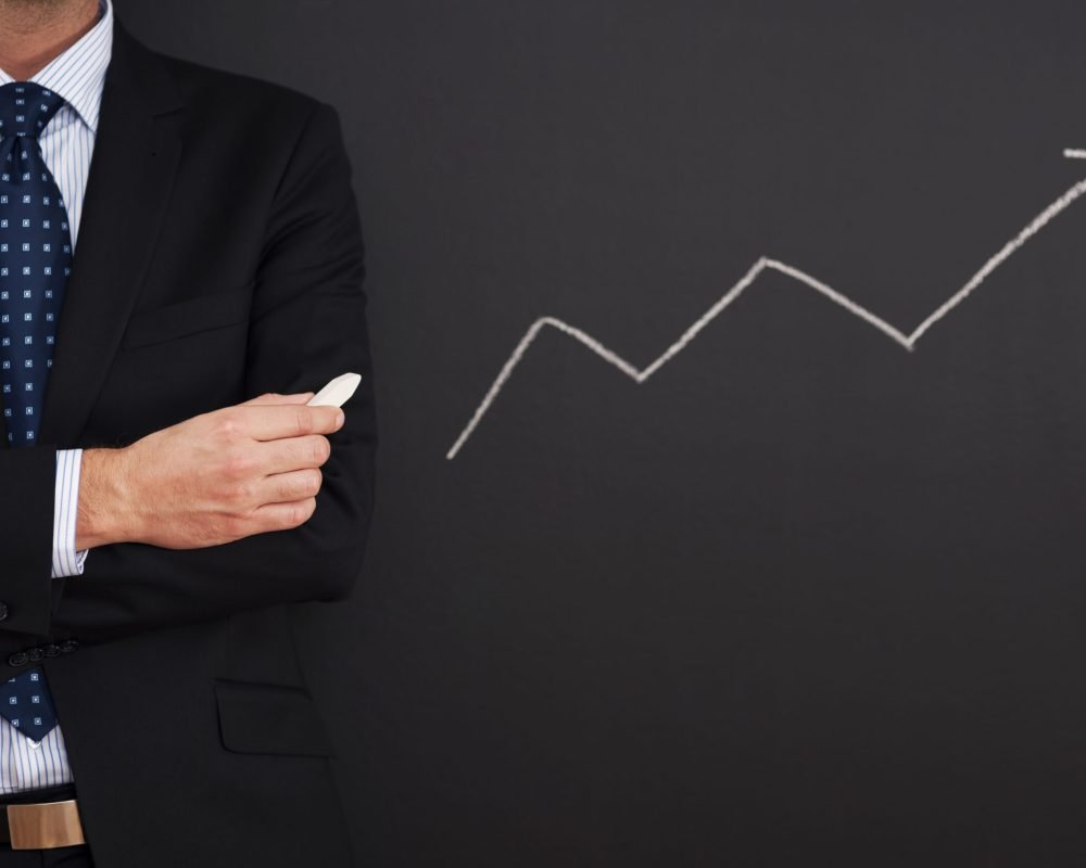 Businessman standing close to arrow sign
