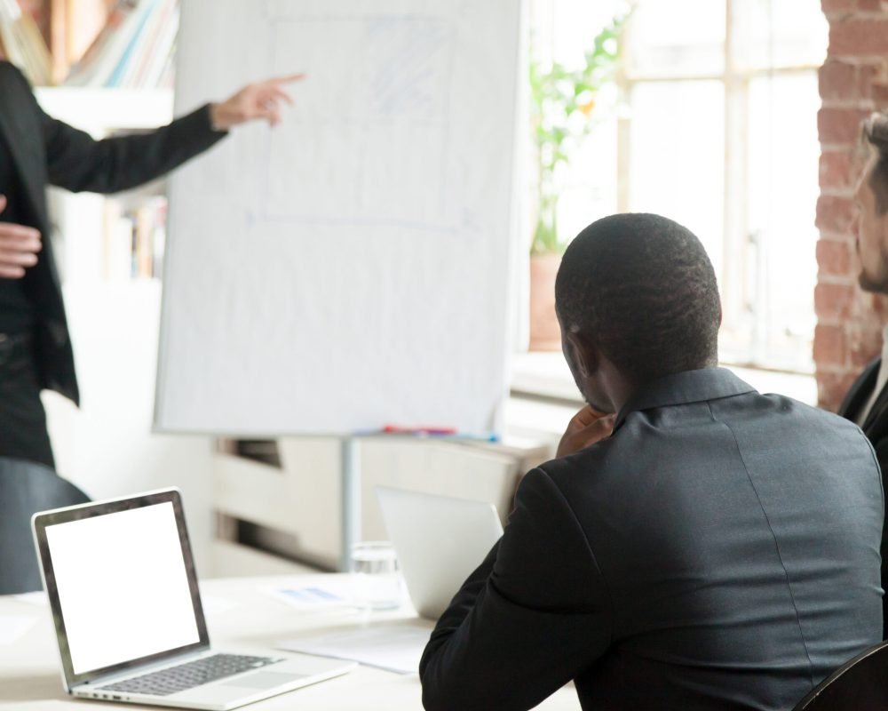 Rear close up view of businessmen team listen to business consultation during briefing. Male project manager showing new corporate plan. Employee training, corporate briefing, company meeting concept
